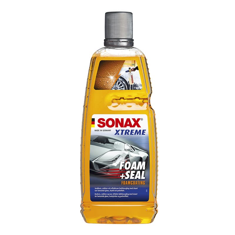 SONAX bilvårdsprodukt i genomskinlig plastflaska med grå skruvkork. Foam + Seal är orange i färgen och syns genom förpackningens 1-literflaska. På framsidan av flaskan sitter etiketten med logga, produktnamn och en futuristisk grå sportbil. Högst upp på flaskan finns även en how-to-bild som extra information.